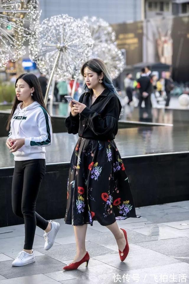 衬衫 小姐姐身穿宽松衬衫,搭配鲜艳的印花半身裙,显得格外的靓丽