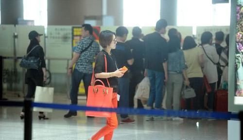 马伊琍穿黑色上衣，搭橙红色的休闲裤，打扮时髦且拉风！