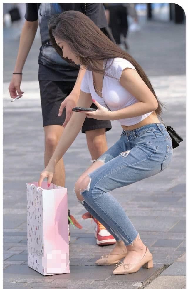 街拍美女紧身牛仔裤小姐姐帮人捡起掉落物品,心地善良的女神