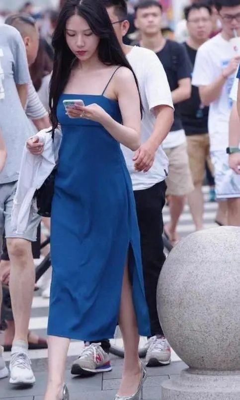 妹妹 妹妹背着一件上衣逛街,穿着幽蓝长裙,带着银色高跟鞋,气质不错