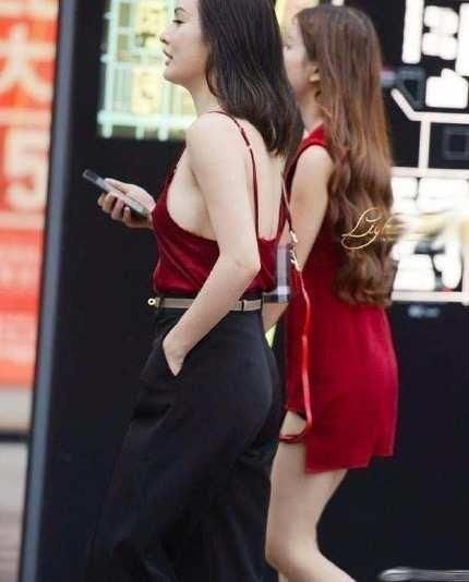 街拍小姐姐身穿红色吊带背心性感娇艳,搭配休闲裤帅气又随性