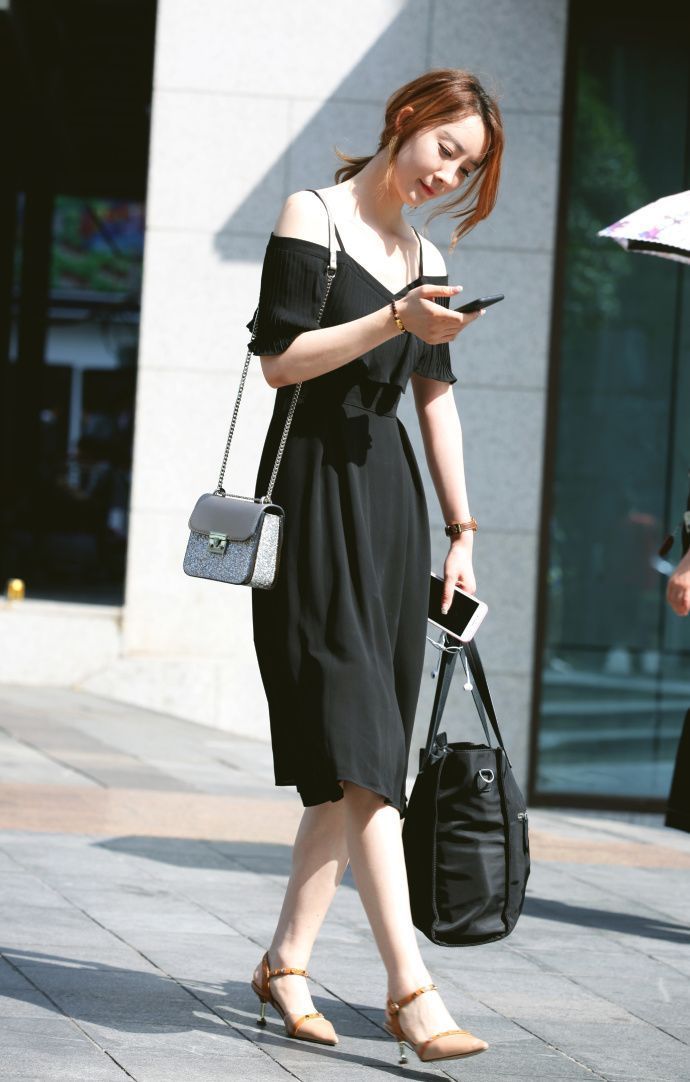 街拍:身材高挑的美女,黑色的牛仔裤搭配针织背心,彰显年轻的风采