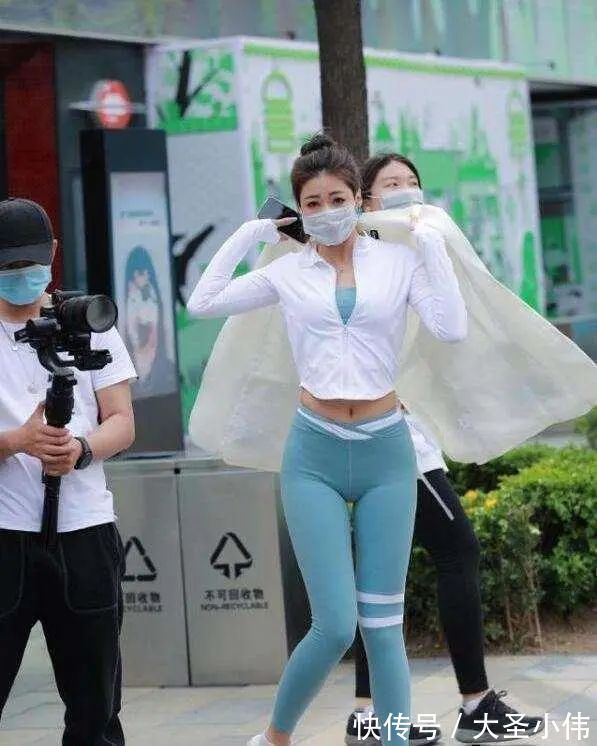 露脐短袖 美女街拍:白色露脐短袖搭配黑色打底裤,可爱显瘦,年轻女孩的必备穿搭