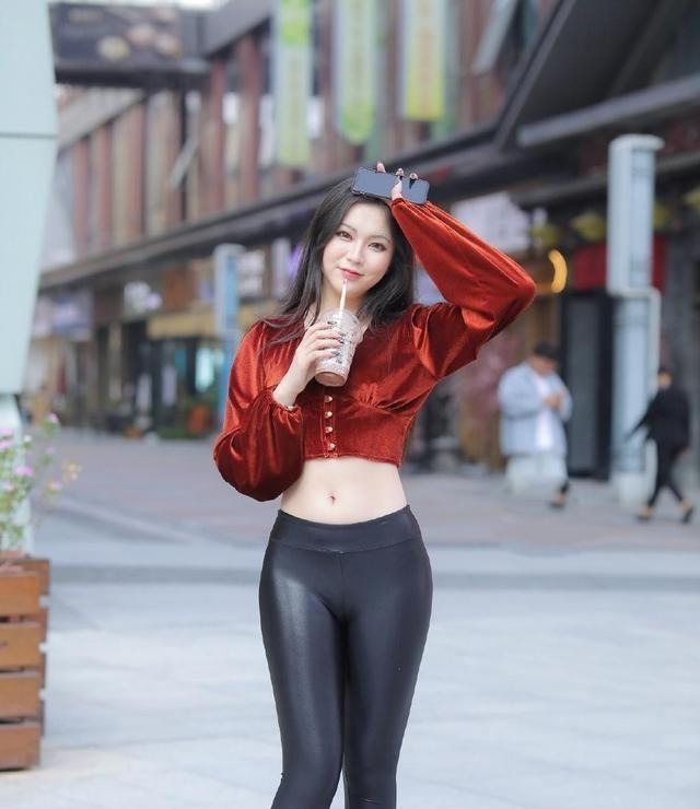 丝绒上衣 美女穿深褐色的丝绒上衣配皮裤,露出美丽腰线,散发出魅力