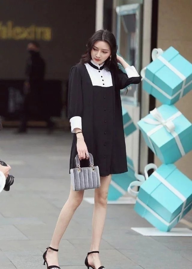黑色|街拍穿着格子鞋子的小姐姐,一条黑色的长裙穿搭的非常时髦