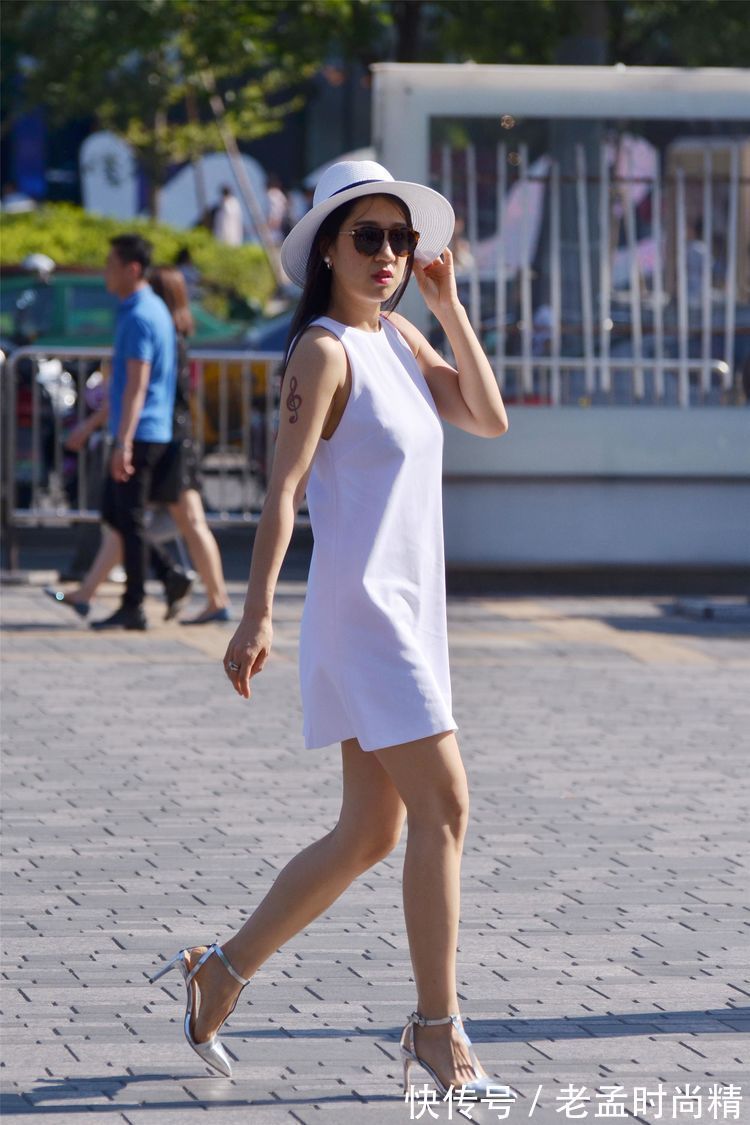 连衣裙 街拍:美女一件白色无袖连衣裙,搭配一顶草帽,非常时尚漂亮!