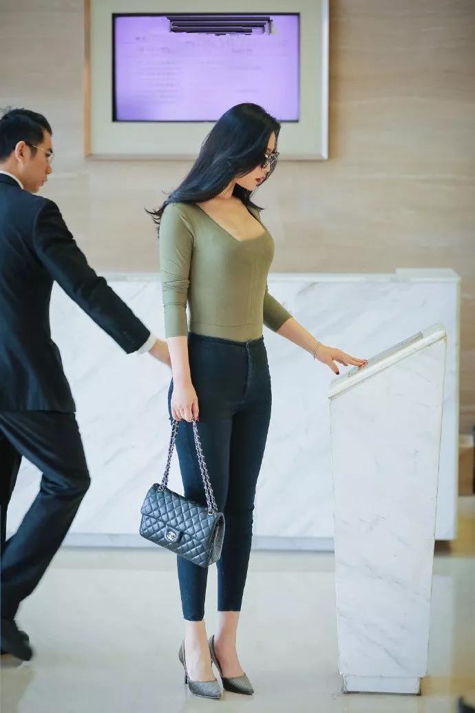 街拍小妹妹穿着浅绿色的V领上衣,苗条的身材勾勒出她优雅的身材