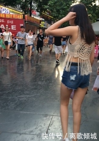 镂空|街拍:美女蓝色紧身高腰牛仔裤搭镂空线衣,给人时尚清凉的感觉