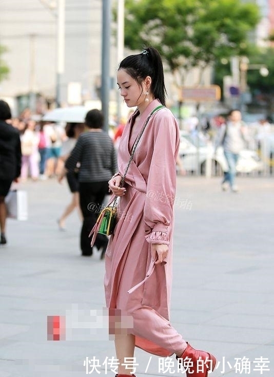 路人街拍,小姐姐下身穿的是一件白色的牛仔短裤,展示白皙的双腿