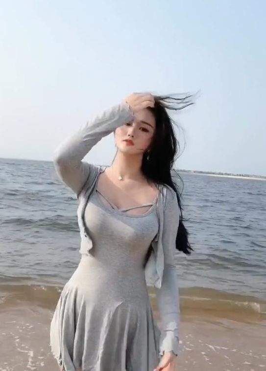 小姐姐 小姐姐头发被海风吹的“凌乱”美，吊带裙打扮起来性感似美人鱼