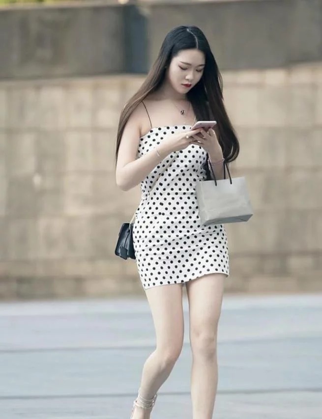 街拍:身穿红色抹胸连衣裙的美女,白皙的香肩与修长美腿,温婉可人