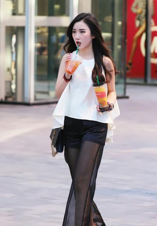街拍丰标不凡的美女,白色短袖配黑色长裤,女神范十足