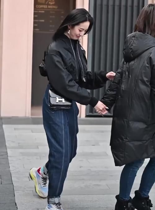 街拍美女黑衣蓝裤的小姐姐好帅气，抬脚就被“猫印鞋”抢镜了