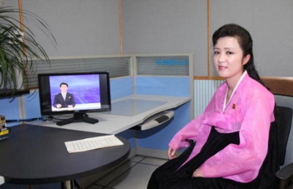 图为朝鲜央视女主播,身着朝鲜特色上粉下黑的裙服,有一种别样韵味.