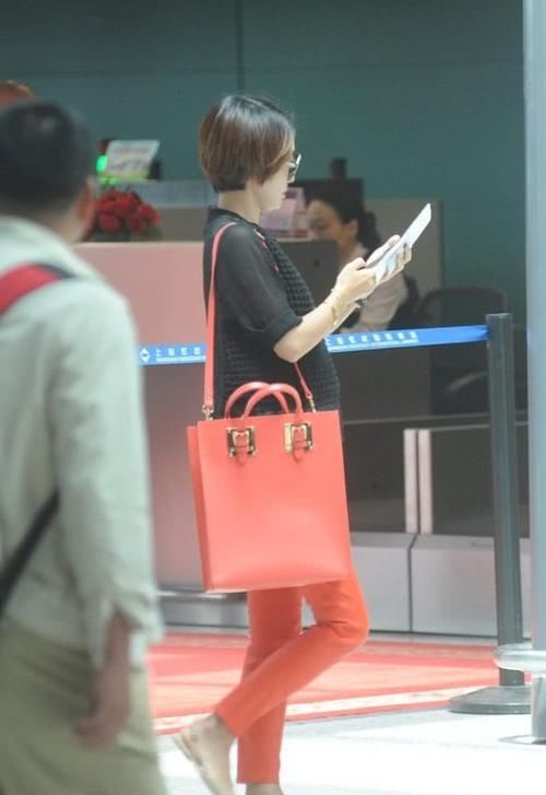 马伊琍穿黑色上衣，搭橙红色的休闲裤，打扮时髦且拉风！