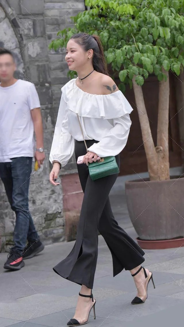 喇叭裤 皮肤白皙的美女,一件白色露肩上衣搭配黑色喇叭裤穿搭出众显贵气