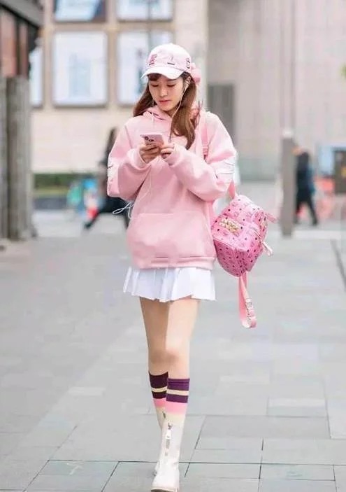 街拍:身材纤细的美女,卫衣配短裙,展现出青春靓丽气息