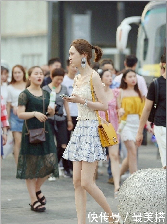 起舞|街拍:小姐姐身穿一件黑色吊带连衣裙,裙摆随风起舞