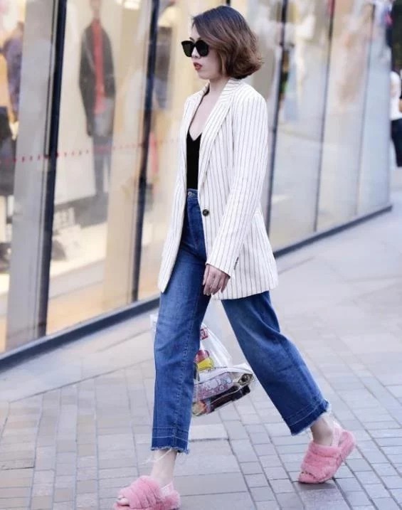 街拍皮肤白皙的美女,身穿黑色连衣裙,女人味十足