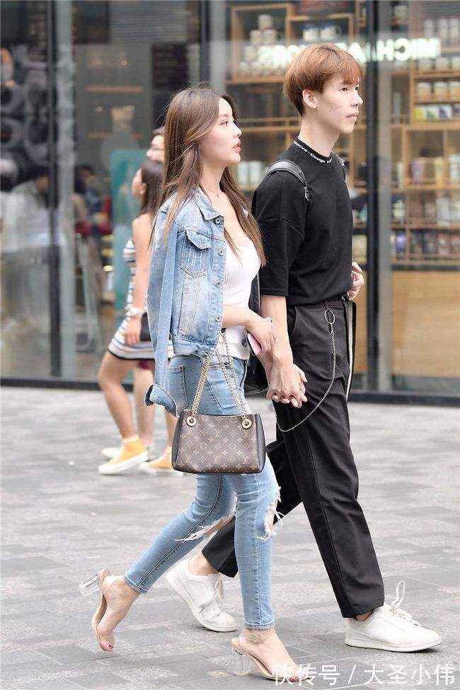 牛仔裤|美女街拍:蓝色紧身牛仔裤,膝盖的破洞很个性,披着牛仔夹克