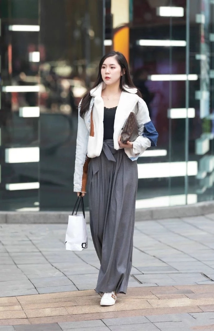 街拍:小姐姐身穿红色无袖上衣,搭配白色的长裤,造型很时尚