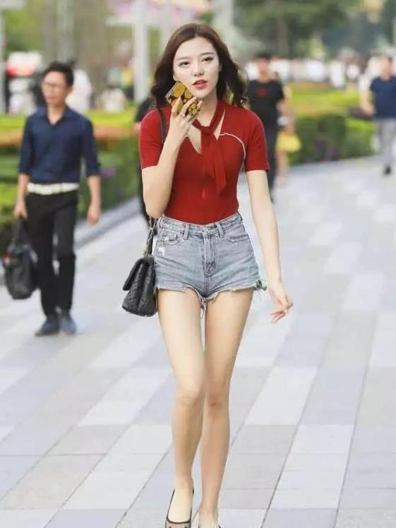 街拍脚步欢快的小姐姐,红色上衣配牛仔短裤,青春活力气质