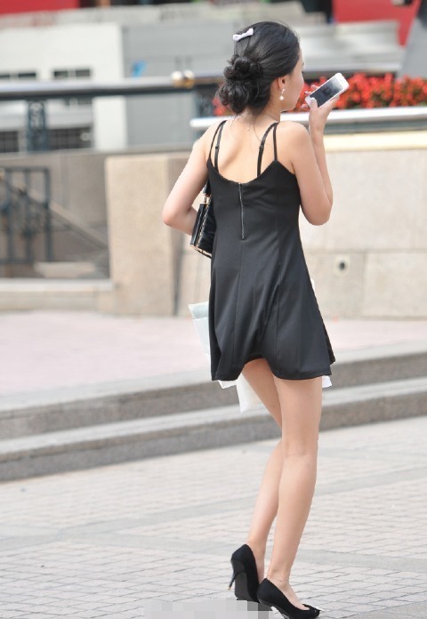 东方女性 黑色吊带裙的美女走路不忘记发语音,是在热恋期吗