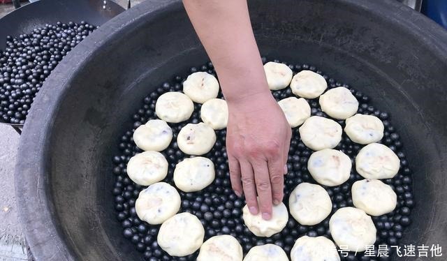  乡村年集上 一男子手拿一把铁锹在石头子上做美食 日进千元