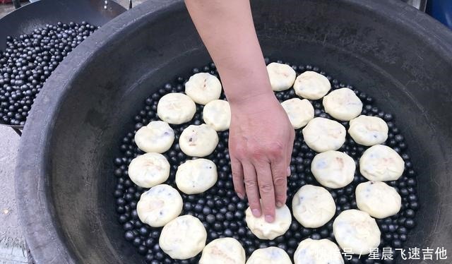 乡村年集上 一男子手拿一把铁锹在石头子上做美食 日进千元