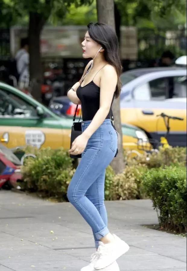 吊带|街拍黑色吊带背心搭紧身牛仔裤的性感姑娘,大方洒脱的气质