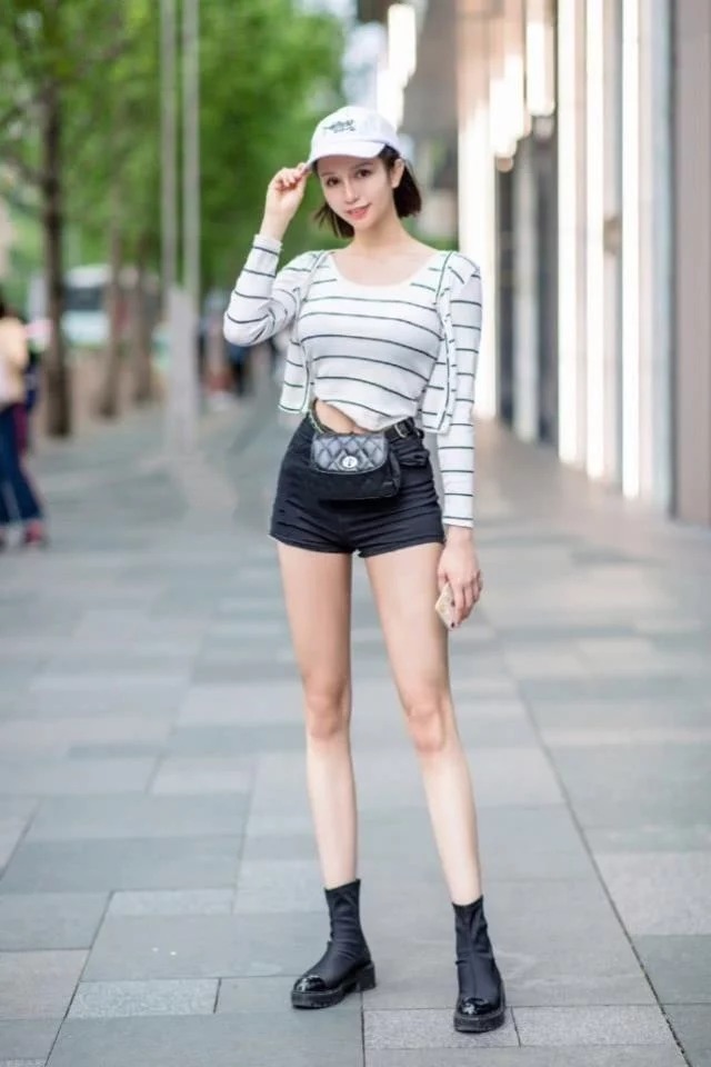 街拍:花枝招展的小姐姐,一件时尚的上衣配短裙,显得妩媚又时尚