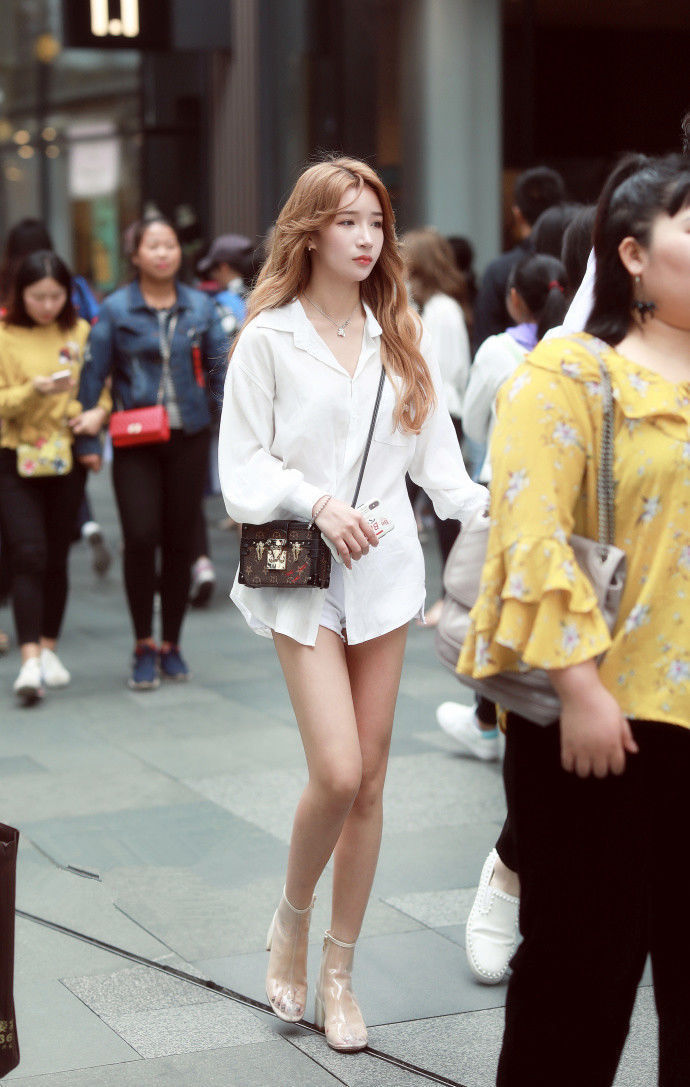 街拍:身材高挑的大眼睛女孩,露出牙齿微笑着,时尚而洋气