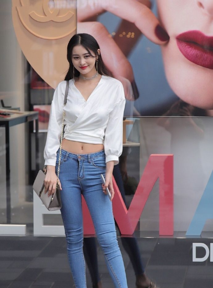 街拍|街拍：蓝色牛仔搭配白色上衣，天鹅颈小姐姐自信美丽