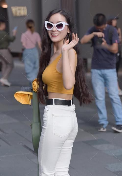 土黄色上衣搭配白色喇叭裤,既显腿长又能释放出女神的气质