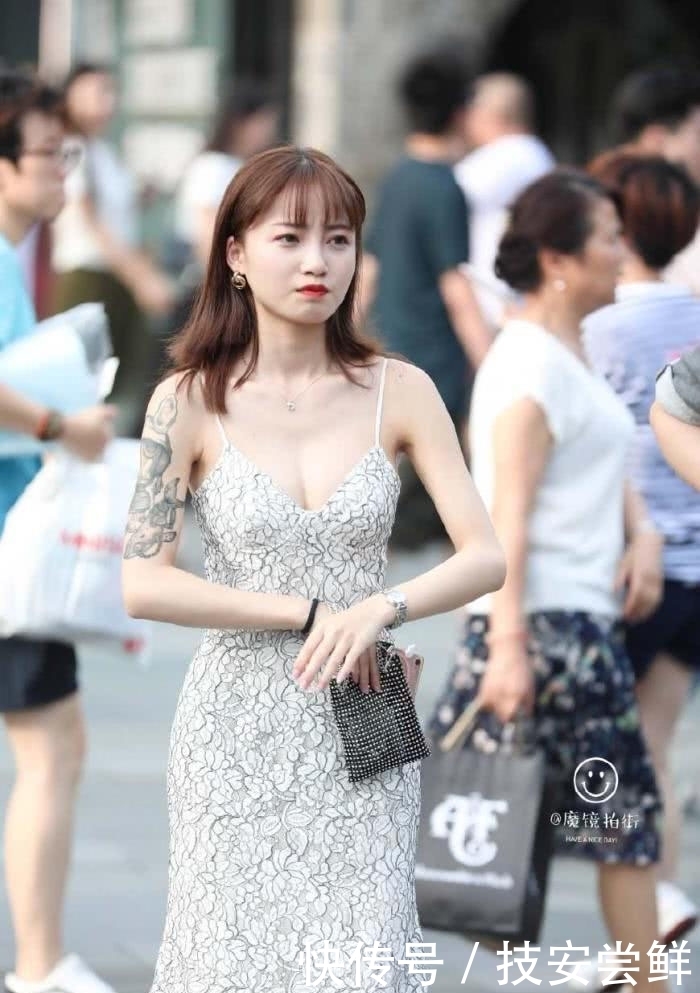 街拍:小姐姐身穿一条白色印花吊带裙,性感中带着一丝文艺小清新