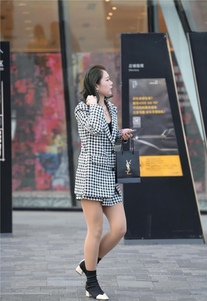 风衣|街拍:美女黑色风衣披在肩上,非常个性,而且笑起来很迷人!