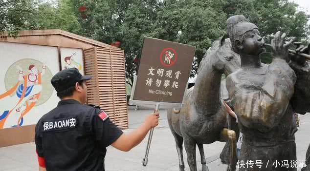 游客攀爬景区雕塑拍照，保安喊话无效后，竟默默地递上了一块牌子