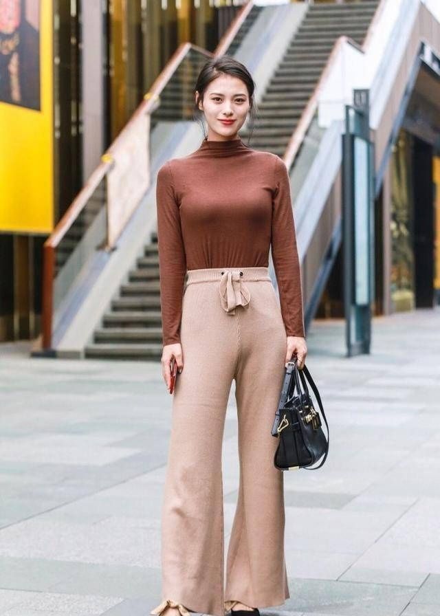 街拍:小姐姐身穿白色的背心搭配上一条半裙,优雅的展示出美丽的双腿