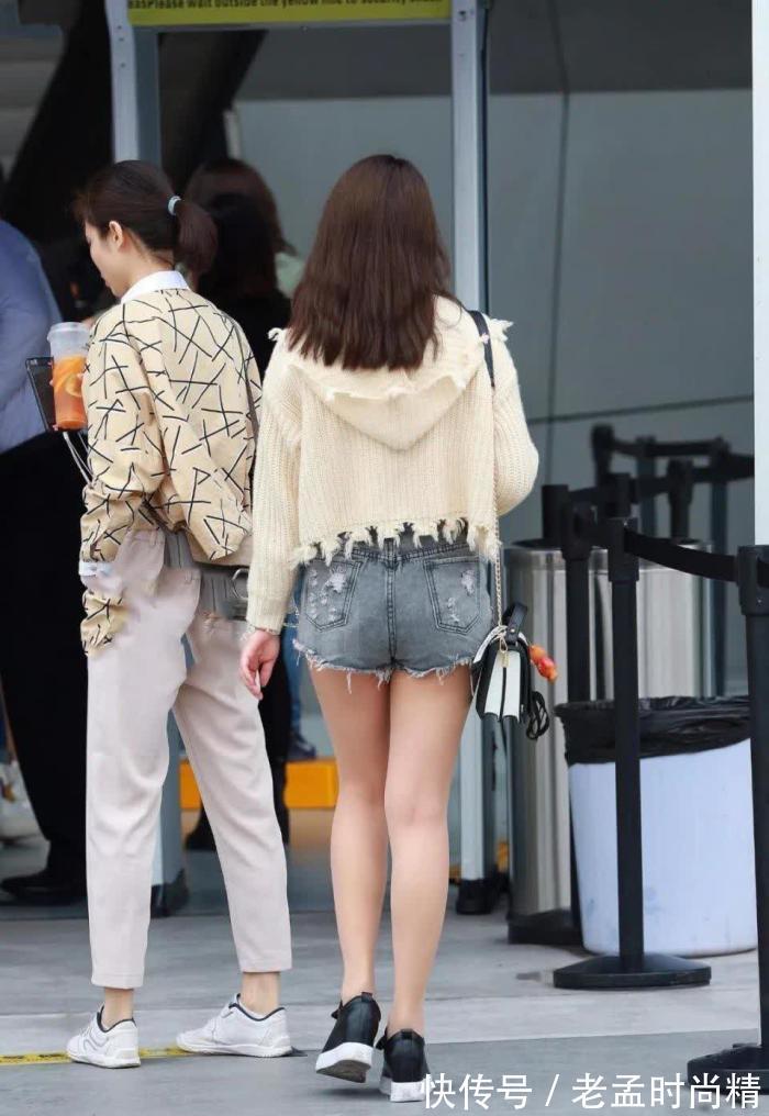 手机 街拍:米黄毛衫搭牛仔热裤的靓丽女孩,走路也不忘玩手机很危险!