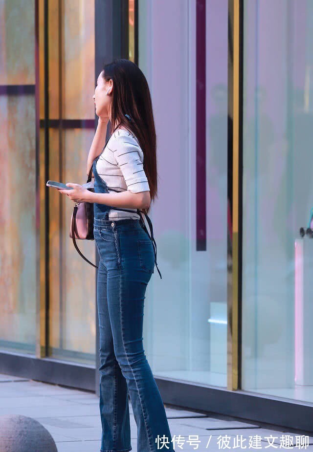 吊带裤 牛仔吊带裤搭配白色V领上衣,散发时尚韵味,彰显高挑身材