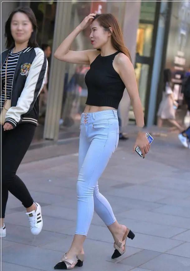 美女黑色无袖短款背心搭浅白色牛仔裤,在人群中具有非常明确显眼