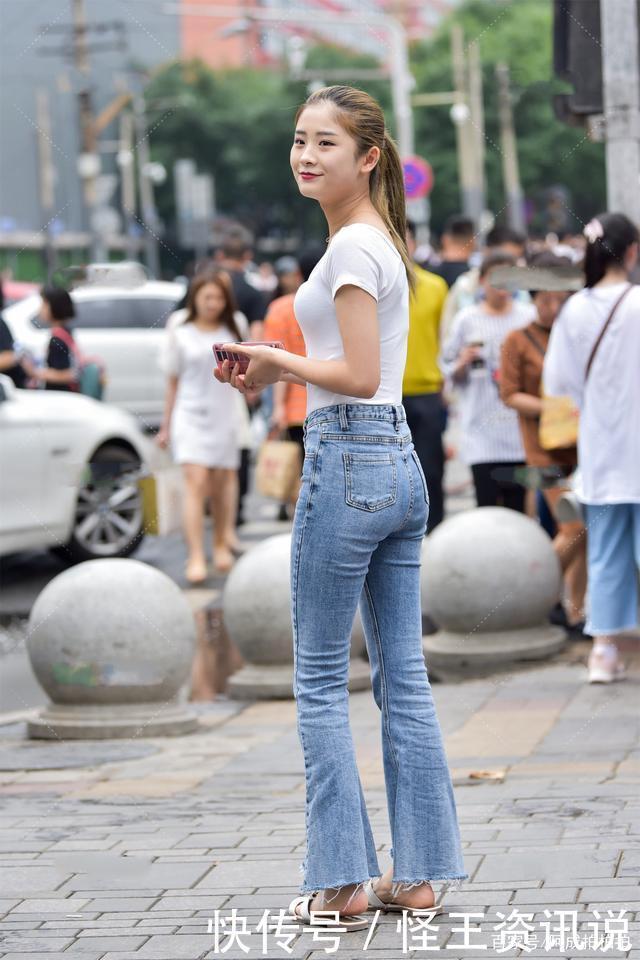 街头休闲风,白色T恤配浅色喇叭腿牛仔裤,马尾辫子更显青春活力