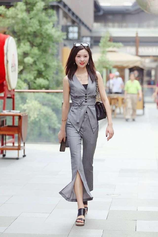 美女|街拍:长发俏皮的美女,白色上衣配牛仔裤,时尚气质十足