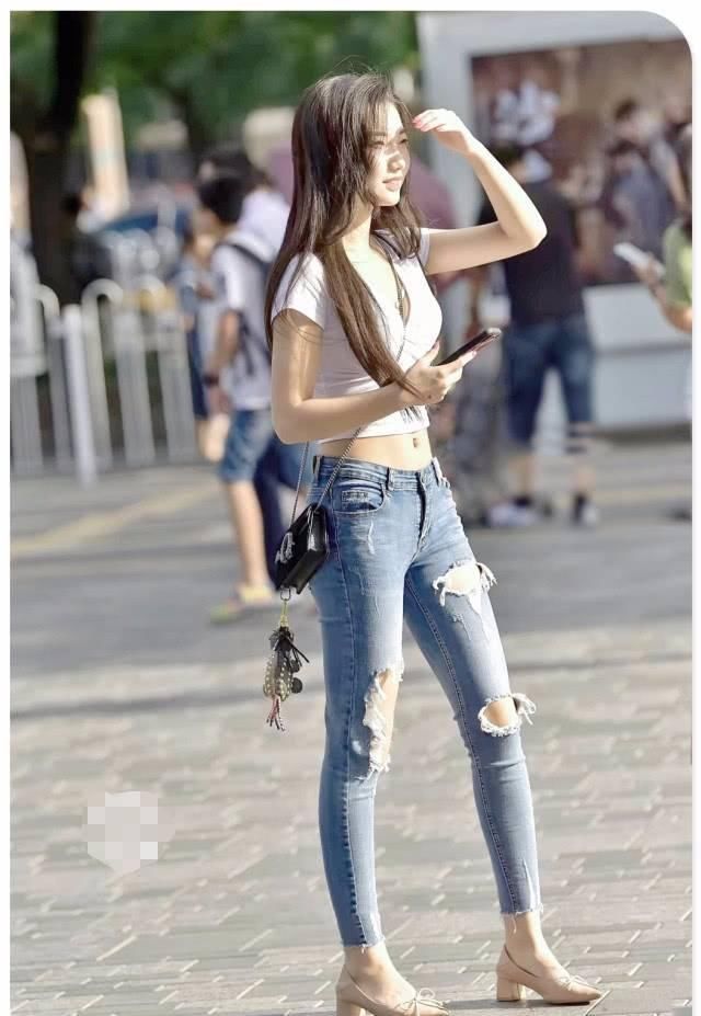 街拍美女紧身牛仔裤小姐姐帮人捡起掉落物品,心地善良的女神