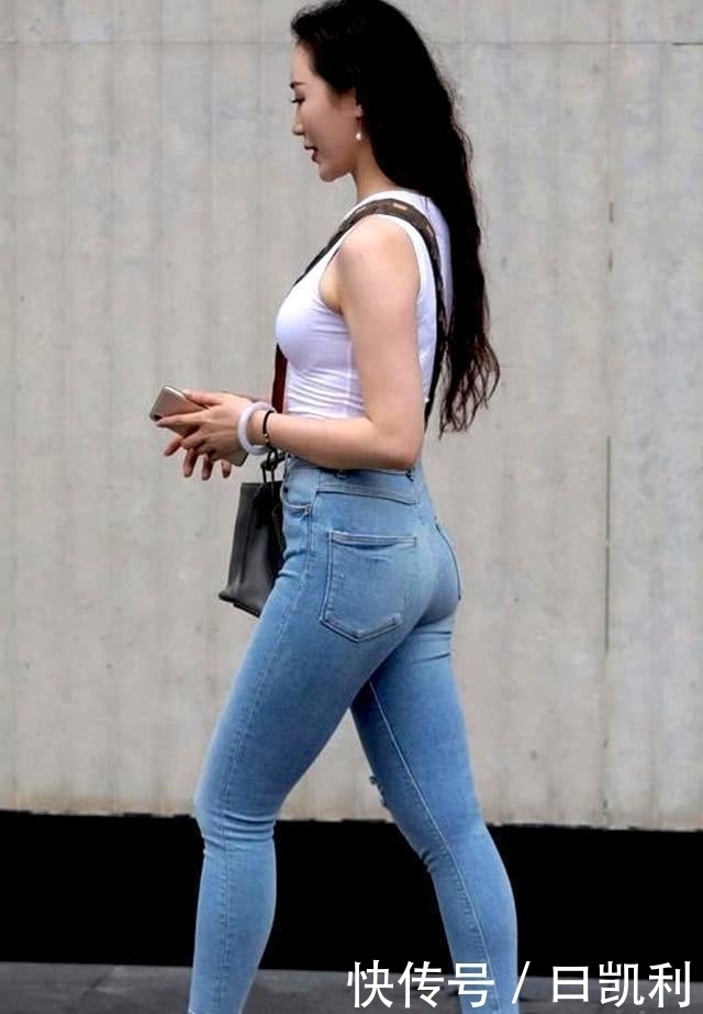 小姐姐穿简约的牛仔裤，配上白色吊带，青春时尚气息十足