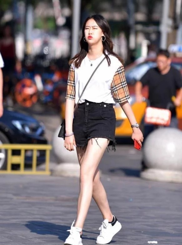 十足|街拍:小美女身穿牛仔短裤配T恤,脚下一双白色运动鞋,休闲味道十足