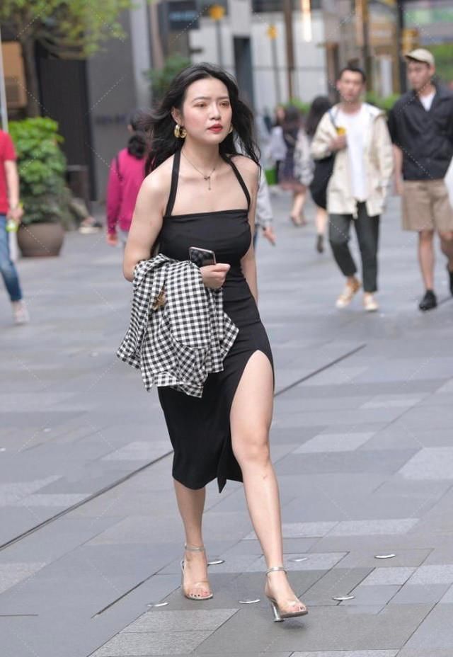 黑色吊带开叉裙格外吸引眼球，穿搭出的气质高雅，银色高跟鞋精致