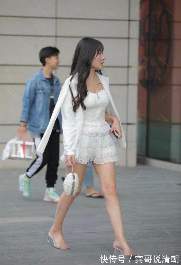 吊带上衣|街拍,美女穿白色高腰款式的吊带上衣,更显娇俏动人