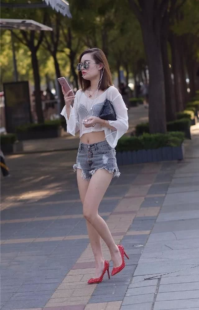 街拍小姐姐的身材十分的完美，身穿酒红色的上衣，带着一种成熟的气息