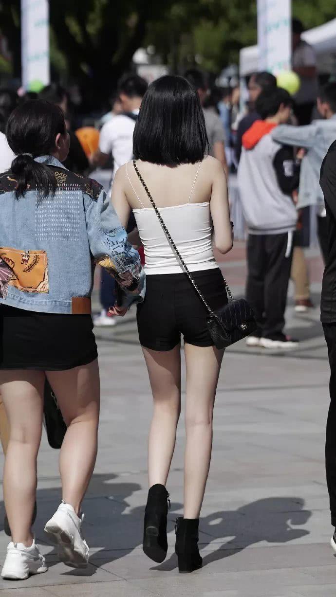打底裤|时尚街拍紧身的白色小吊带，搭配黑色打底裤，长腿是如此动人